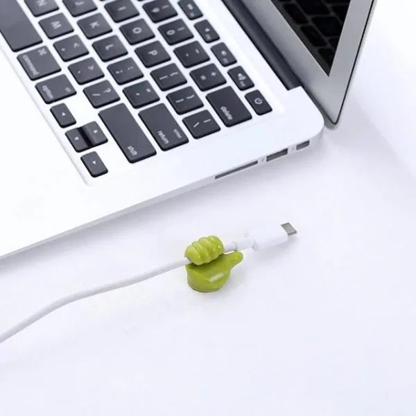 Green cable tie holding a white USB cable to a laptop on a white surface