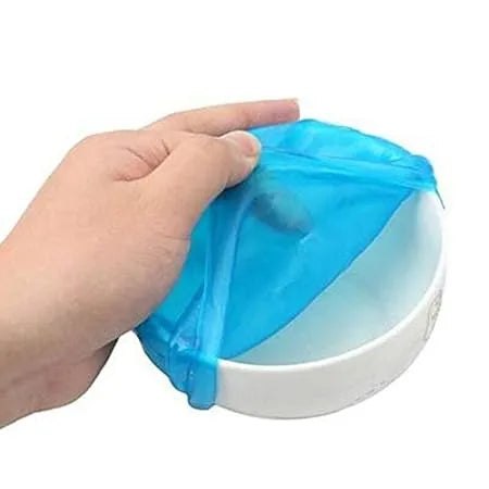 Hand using a blue plastic bag dispenser on a white background