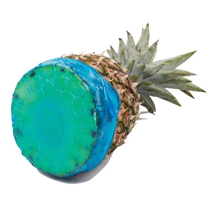 Pineapple with a blue and green painted top on a white background