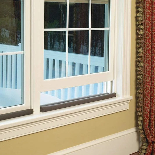 Window with white frame and decorative curtain on a wall.