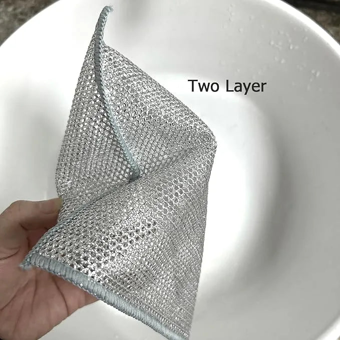 Two-layer metal scrubber held over a white sink.