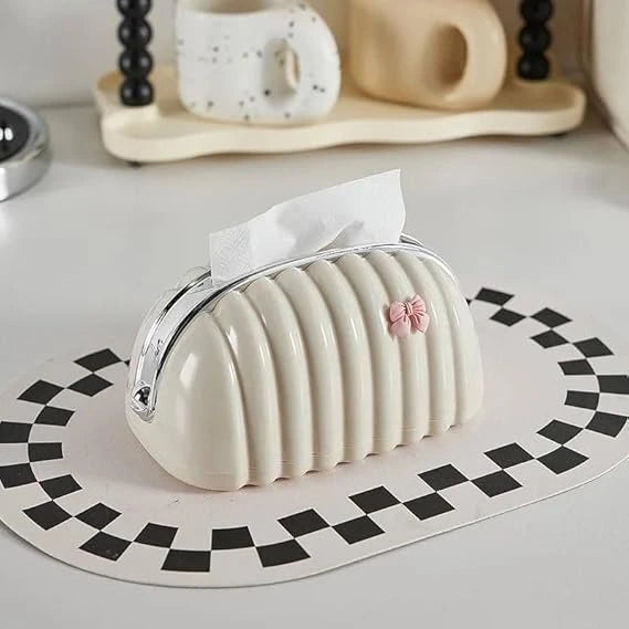 White ribbed tissue holder with a pink bow on a checkered mat