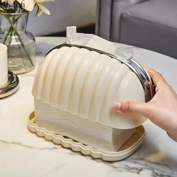 Beige bread toaster with a hand lifting a slice of bread, placed on a marble surface.