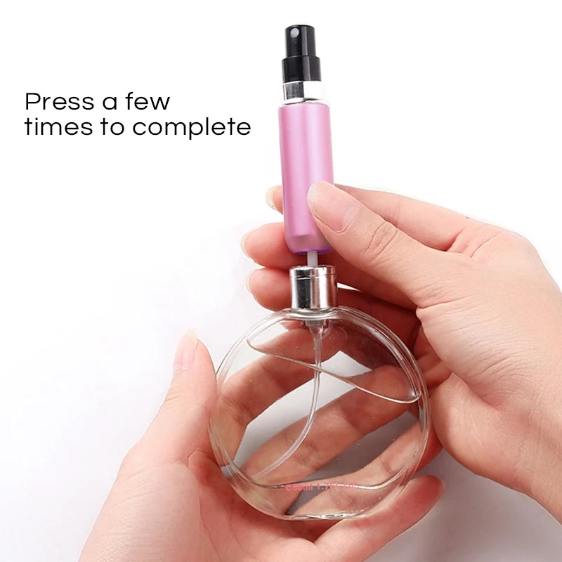 Clear perfume bottle with pink spray cap held by a hand on a white background