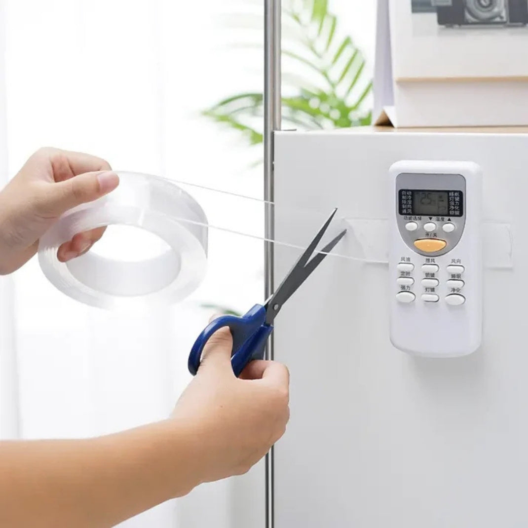 Person cutting clear tape with scissors on a white appliance.