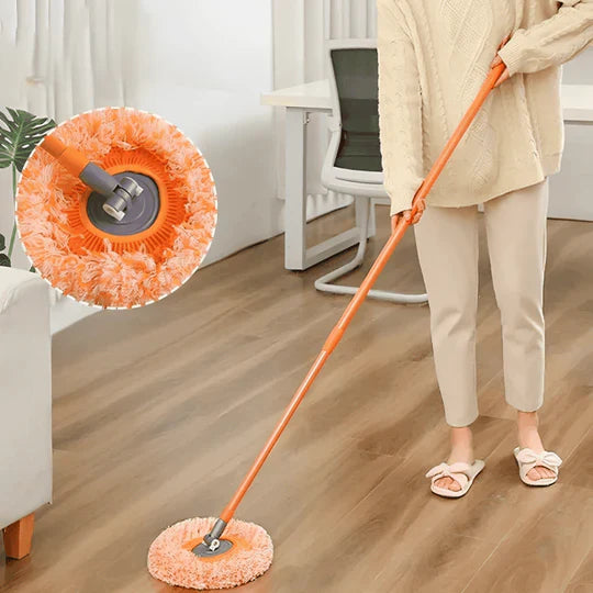 Person cleaning a wooden floor with an orange cleaning tool, close-up of brush head.