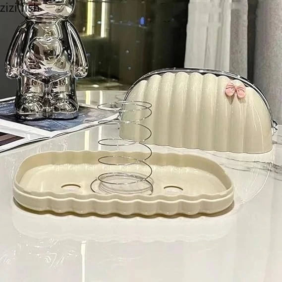 Beige tray with scalloped edge and pink bow on a reflective surface.