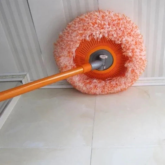 Cleaning tool with orange handle and scrubber head cleaning a floor.